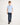Young boy wearing a light blue polo shirt and dark jeans on a white background