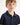 Young boy wearing a navy blue polo shirt against a white background