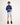 Young boy wearing a dark blue workshirt and light blue shorts on a white background
