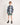 Child wearing a blue plaid shirt and green shorts on a white background