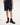 Boy wearing navy shorts with striped cuffs and brown boots on a white background