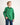 Boy wearing a green workshirt with a plain background