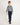 Young boy wearing a green and white checkered shirt and blue jeans on a white background