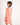 Young girl wearing a pink and orange striped dress on a white background
