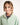 Young girl wearing a light green jumper with a white background