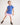 Young girl wearing a blue polo shirt and pink shorts on a white background