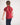 Young girl wearing a red polo shirt with a navy collar against a white background