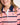 Young girl wearing a pink and navy striped polo shirt on a white background