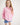 Girl wearing a pink workshirt with a visible RB logo on a white background