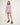 Girl wearing a pink workshirt with a visible RB logo on a white background