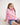 Girl wearing a pink workshirt with a visible RB logo on a white background