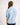Girl wearing a light blue button-up workshirt on a white background