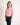 Young girl wearing a pink patterned shirt and dark jeans on a white background