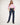 Woman wearing a pink shirt and blue jeans on a white background