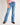 Young girl wearing a pink t-shirt and blue jeans on a white background