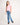 Young girl wearing a pink t-shirt and blue jeans on a white background