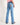 Girl wearing blue jeans with a horse design on the back pocket against a white background