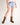 Girl wearing brown cowboy boots and light blue denim shorts on a white background