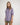 Girl wearing a purple workshirt and green shorts on a white background