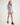 Girl wearing a purple workshirt and green shorts on a white background