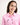 Young girl wearing a pink workshirt with a brand logo on a white background