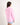 Young girl wearing a pink workshirt with a brand logo on a white background