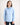 Young girl wearing a light blue workshirt and dark jeans on a white background