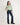 Young girl wearing a light green shirt and dark blue jeans with a white background