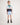 Young boy wearing a striped polo shirt and light blue rugger shorts on a white background