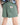 Green shorts with a brand label on a plain background
