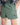 Green shorts with a logo on a plain background