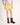 Girl wearing yellow shorts and brown cowboy boots on a white background