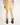 Girl wearing yellow shorts and brown cowboy boots on a white background
