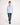 Young boy wearing a light blue sweater and jeans on a white background