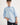 Boy wearing a light blue workshirt with rolled-up sleeves on a white background