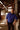 Man in a blue shirt standing inside a rustic wooden building