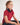 Young girl wearing a red polo shirt with a navy collar against a white background