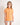 Young girl wearing an orange polo shirt against a plain background