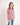 Young girl wearing a pink and navy striped polo shirt on a white background
