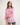 Girl wearing a pink workshirt with a visible RB logo on a white background