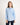 Girl wearing a light blue button-up workshirt on a white background
