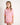 Young girl wearing a pink checkered shirt with orange accents on a plain background