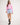 Girl wearing a pink workshirt and light blue rugger shorts on a white background