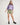 Girl wearing a purple workshirt and green rugger shorts on a white background