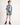 Young boy wearing a plaid shirt and green shorts on a white background