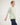 Young boy wearing a light green striped shirt and blue jeans on a white background