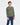 Young boy wearing a green and white striped shirt and blue jeans on a white background