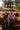 Three children sitting on a metal cart with cows in the background on a farm.